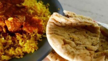 Chicken Korma curry with Pilau rice and naan bread overhead close up 4k zoom shot slow motion selective focus