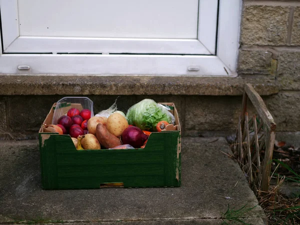 Box of fresh vegetables and fruit delivered to customer home medium shot selective focus