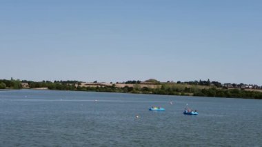 Tourists enjoying boat trip on lake wide establishing shot slow motion selective focus