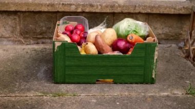 Bir kutu taze sebze ve meyve müşteriye teslim edilir. Orta ölçekli, seçici odak noktası. 