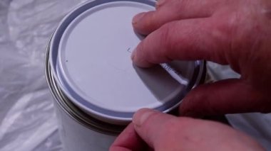 Bir kutu beyaz parlak boya açıyorum. Yakınlaştır. Yavaş çekim seçici odak noktası. 