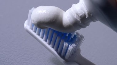 Diş fırçasına diş macunu sıkmak makro yavaş çekim seçici odak noktasını kapatmak