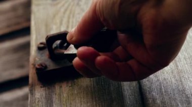 Kırsal ahşap kapı 4K 'da metal kilidi açmak seçici bir odak noktası.