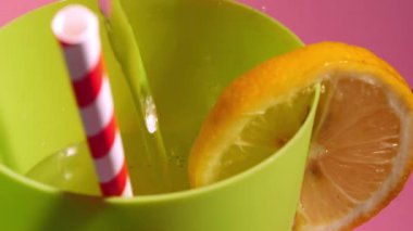 Dilimlenmiş limonlu soğuk içecek ve pipet içmek makro 4K seçici odaklanma sağlar.