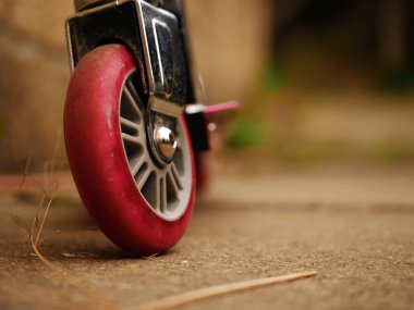 Kameraya doğru giden yolda çocuk scooter tekerleği seçici odağı kapat