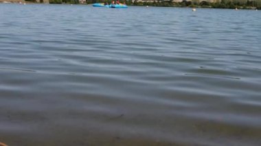 Tekne gölü, turistlerle dolu. Uzakta gölde tekne gezisinin keyfini çıkarıyorlar. Yavaş çekim seçici odak noktası oluşturuyorlar.