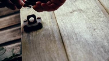 Eski ahşap barakayı asma kilitli 4K orta kalibreli seçici odak noktası ile güvenlik altına alıyorum.