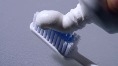 Diş fırçasına diş macunu sıkıştırılıyor Makro 4k yavaş çekim seçici odak