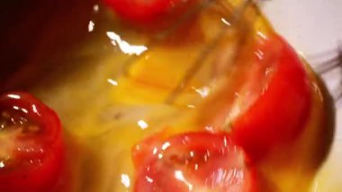 Omlet makrosu için çırpılmış yumurta ve domates yakın çekim yavaş çekim seçici odaklanma