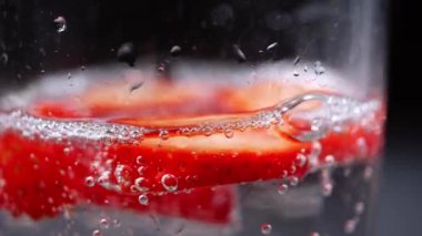 Dilimlenmiş çilek makrosu ile karıştırılmış buzlu içecek yavaş çekim seçici odak noktası yakın çekim