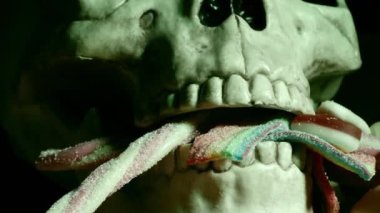 Cadılar Bayramı 'nda şeker ya da şeker için şeker taşıyan ürkütücü kafatası. Dolly 4K' yı yakın çekim. Seçici odak noktası. 