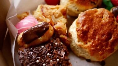 Kremalı çay ve kek seçimi. Çilekli tatlılar ve çilekler. Tepeden 4k 'lik seçici odaklanma.