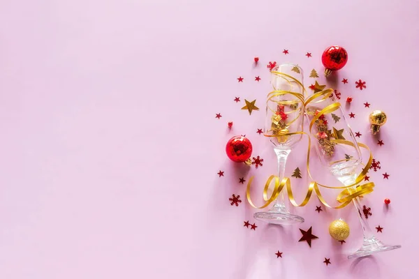 シャンパングラスコンフェッティとサーペンタインとクリスマスツリーの装飾ピンクの背景と場所のためのテキスト幸せな新年クリスマスの休日 — ストック写真