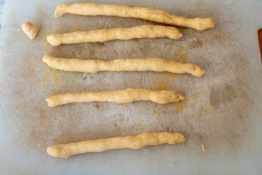 struffoli 1 'i hazırlayın. Yumurta, un, Marsala şarabı ve şekerden yapılan hamuru bir sopa şeklinde yuvarla ve parçalara böl.