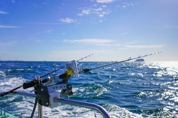 Go fishing on the ocean: the fishing rod, sea and blue sky