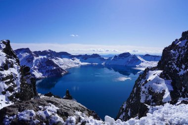 Kışın kar altında mavi volkanik göl, Tianchi 'nin kuzey yamacında Changbai Dağı' nda Çin ve Kuzey Kore arasındaki sınırda.