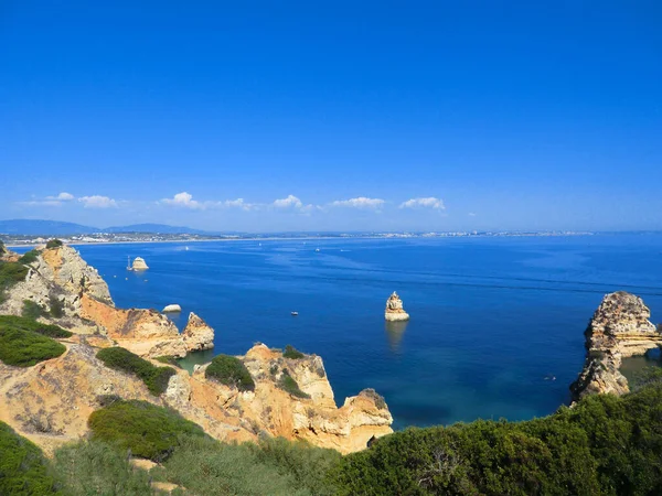 Algarve, Portekiz 'de bir plaja, altın kayalara ve mavi denize bakan