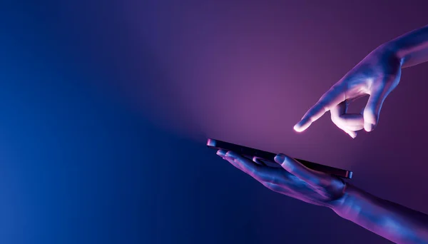 3D eller bir cep telefonu tutuyor ve ekranı işaret ediyor. Neon ışıkları. Fütürist konsept, teknoloji, metaevren ve kripto. 3d oluşturma