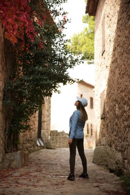 Çok eski bir kasabanın sokaklarında yürüyen ve eğlenen bir kadın.