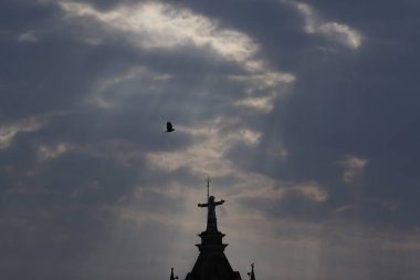 Doğal manzara, bulutlar arasındaki güneş ışınları kilise kulesindeki haça odaklı, barış kavramı..