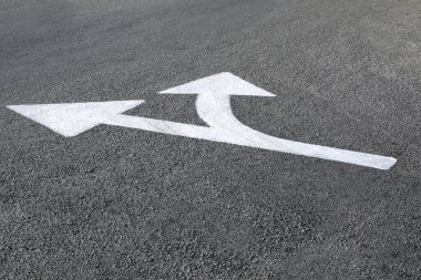 Asfalt zemine beyaz yönlü ok çizildi - yollar ve yönler kavramı