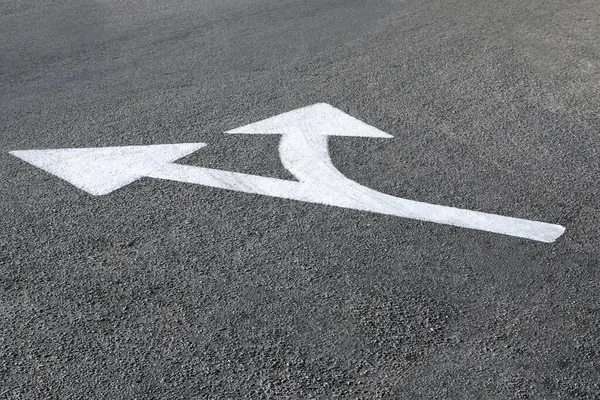 Asfalt zemine beyaz yönlü ok çizildi - yollar ve yönler kavramı