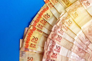 Brezilya 'nın parası mavi yüzeye yığılmış - birkaç gerçek banknot