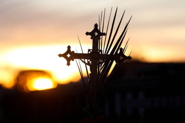 Kutsal hafta. Güzel günbatımı manzarasında tören haçı ve dallar. Geleneksel Katolik kutlaması Palm Sunday. Hristiyan inancı Dini sembol