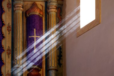 Dini sembol mor renkli kumaş ve pencere ışığından gelen haç ışınlarının tasarımı.