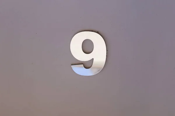 number nine in metallic plate format, with copy space and gray tone - 9