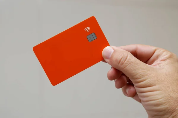 orange credit or debit contactless card with contact less sign. Digital payment system.