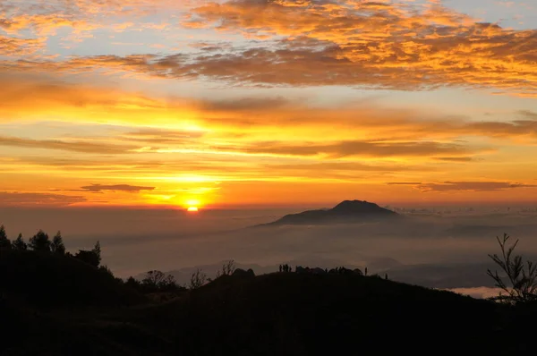 stock image We can see this golden sunrise at the top of Mount Prau, Wonosobo, Central Java, in April 2016. The combination of a very dramatic sunrise, sky and clouds makes this place highly sought after by tourists, especially photographers.