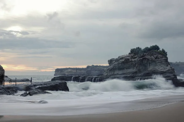 Klayar Beach, Pacitan, white sand beach. A stretch of white sand with clear waves breaks the beach, flanked by two coral hills on the right and left. on the right we can enjoy the beautiful view of Klayar Beach from the viewing post.