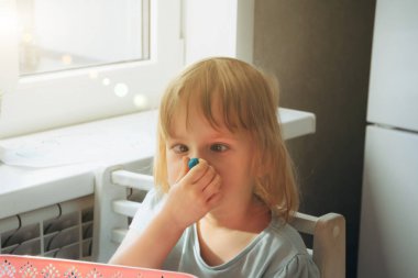 Oyun hamuru oynayan komik çocuk. Kız plastikçeyi burnuna dayadı ve ona baktı..