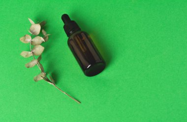 Yeşil zemin üzerinde sıvı olan cam şişe..