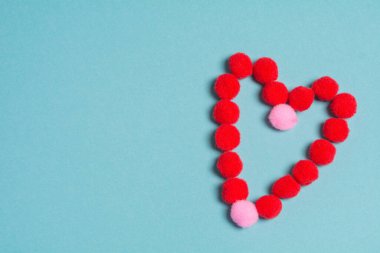 Mavi arka planda tüylü kırmızı bir kalp. Sevgililer Günü tatili için arka plan. Aşk, romantizm ve şefkat kavramı.