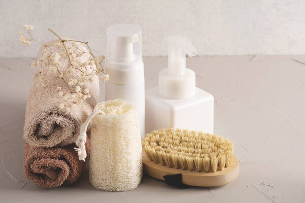 Spa cosmetic products and eco friendly bathroom accessories on gray texture background. Beauty, spa and wellness concept