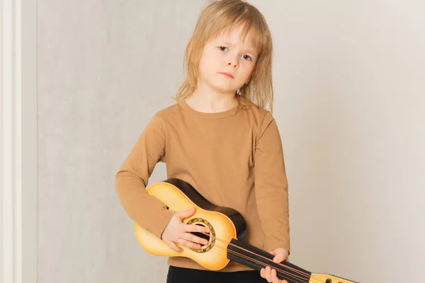 子供は家でギターを弾くことを学ぶ — ストック写真