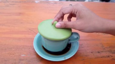 Unscrew the cup of coffee on the table footage video.