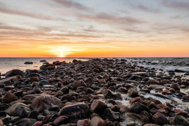 Kayalıklardaki hava kararacak. Tahkuna, Hiiumaa sahilinde gün batımı. Güneş plajda batıyor. Gün batımında dalgalar.  