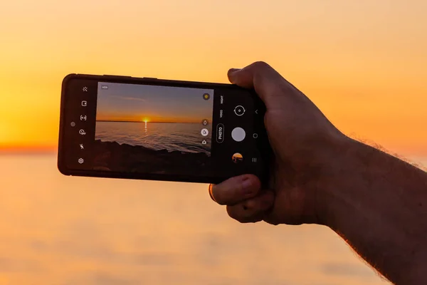 Mão Segurando Telefone Celular Fazendo Foto Pôr Sol Sobre Mar — Fotografia de Stock