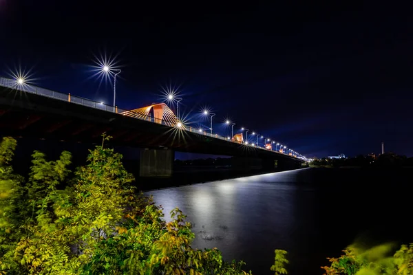 拉托维亚里加南部大桥 拉脱维亚语 Dienvidu Tilts 的夜景 河上桥的蓝夜照片 秋初的夜晚 桥上的路灯正在燃烧 并在水中反射光线 — 图库照片