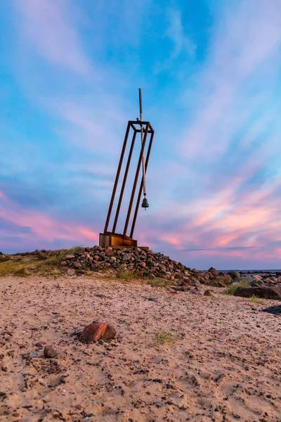 Estonya, Hiiumaa 'daki Tahkuna yarımadasındaki Estonya feribot enkazında kaybolan çocuklar için düşük açılı fotoğraf. Günbatımında çan eşliğinde Rock ve Memorial 'ın dikey fotoğrafı. Anıt, kaya ve güzel renkli gün batımı