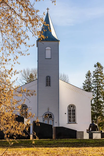 位于爱沙尼亚希乌马的浸信会路德教会的克德拉 Krdla John 教堂在早春时分拍摄的浅蓝色和白色的垂直照片 晴天的路德教会小礼拜堂 追悼会和榛子黄金丝雀 — 图库照片