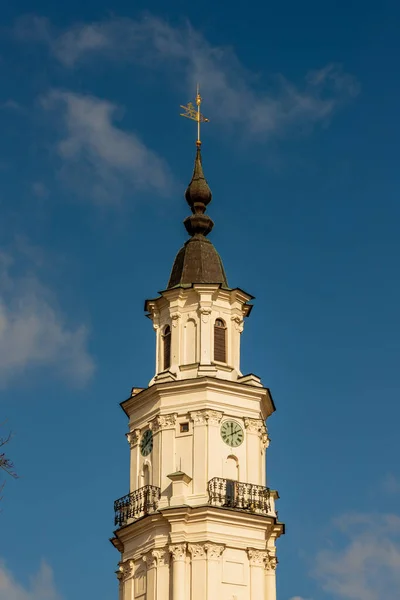 立陶宛考纳斯市政厅的垂直照片耸立在天空背景下 巴洛克象牙色钟塔在下午2点与风箭 考纳斯市政厅白色尖塔 — 图库照片