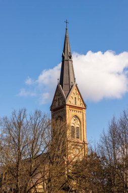 Torakalns Kilisesi, Riga, Letonya. Lüteriyen bazilikasının dikey fotoğrafı beyaz bulut ve mavi gökyüzü arkaplanı. Avrupa Katedral Kulesi güneşte. 