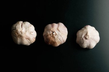 three garlics on a black table. High quality photo