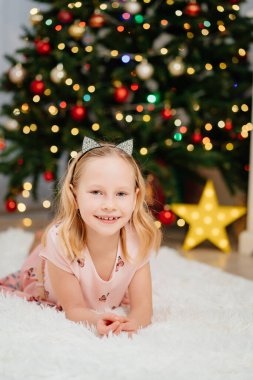 Noel ağacında pembe elbiseli güzel, mutlu sarışın kız..