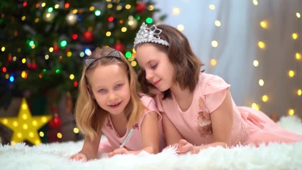 Duas meninas felizes em vestidos cor-de-rosa escrever uma carta para santa claus — Vídeo de Stock