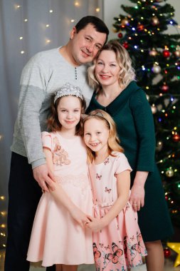 Dost canlısı baba, anne ve iki kız Noel ağacından önce. 